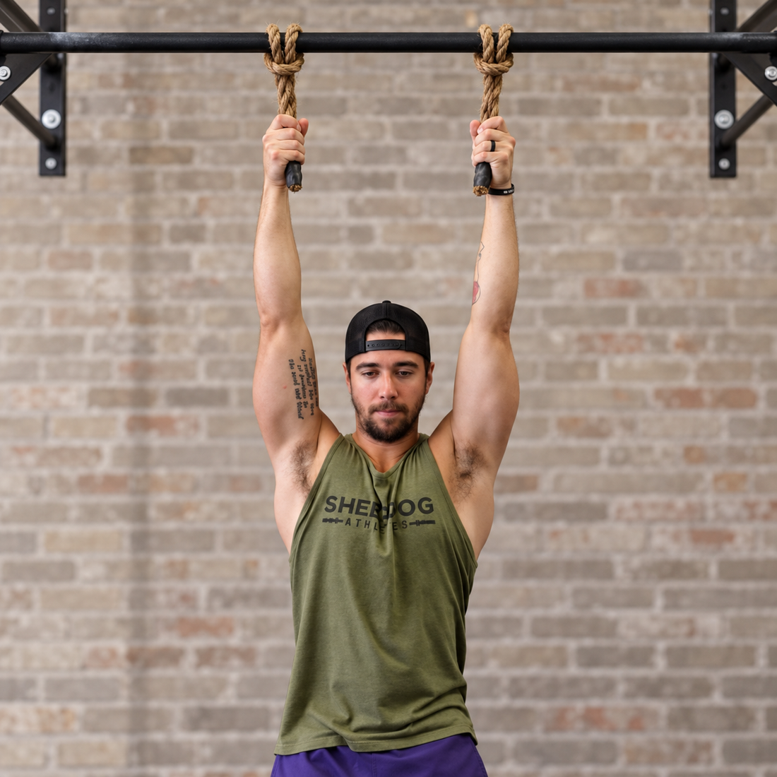 Athlete performing a dead hang using jute Monkee Grips attached to a bar